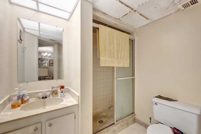 bathroom featuring vanity, walk in shower, tile patterned flooring, and toilet