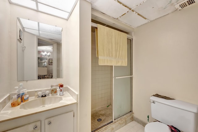 full bathroom featuring vanity, toilet, visible vents, and a stall shower