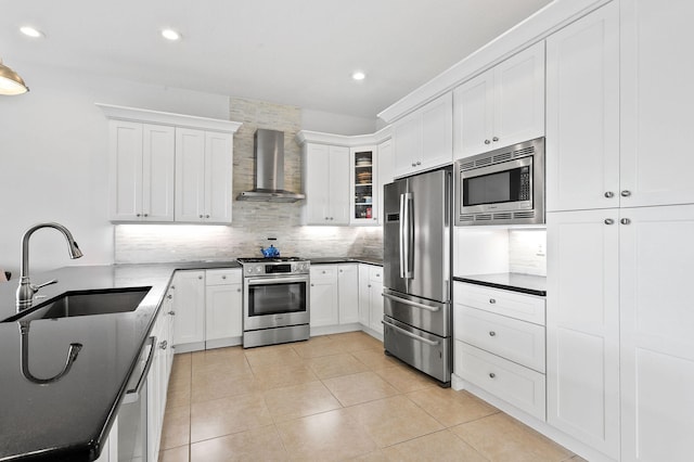 kitchen featuring wall chimney range hood, stainless steel appliances, sink, tasteful backsplash, and light tile flooring