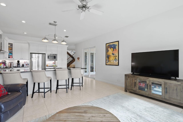 living room featuring ceiling fan and light tile floors