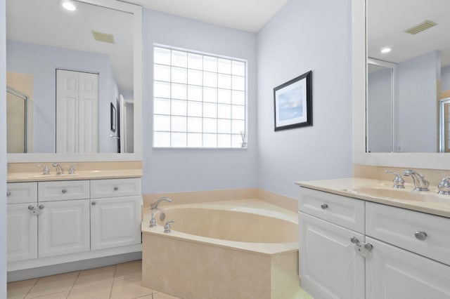 bathroom with a bathtub, tile flooring, large vanity, and double sink