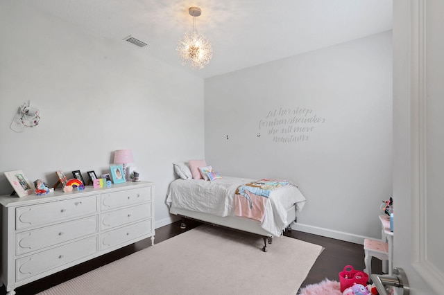 bedroom with a notable chandelier and dark hardwood / wood-style floors