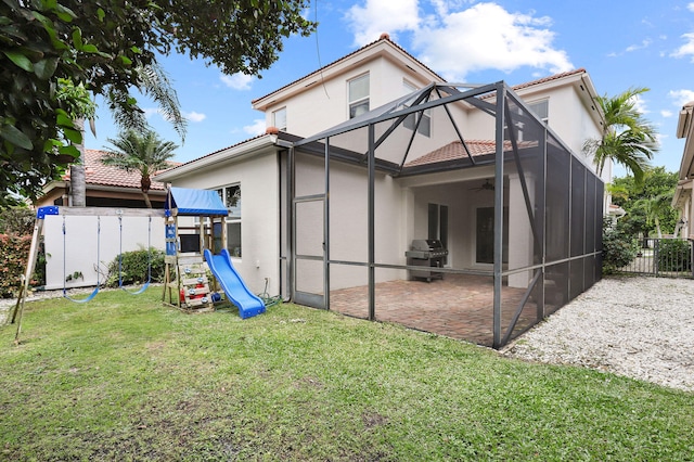 rear view of house with a patio area, a lawn, and a lanai