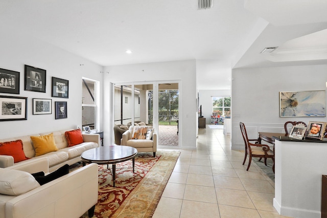 living room with a tray ceiling and light tile floors