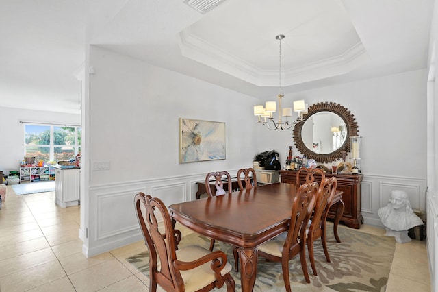 tiled dining space featuring an inviting chandelier and a tray ceiling