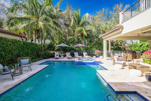 view of swimming pool with a patio area, an in ground hot tub, pool water feature, a grill, and ceiling fan