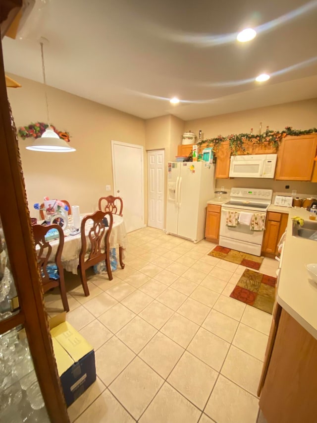 kitchen with decorative light fixtures, white appliances, sink, and light tile patterned flooring