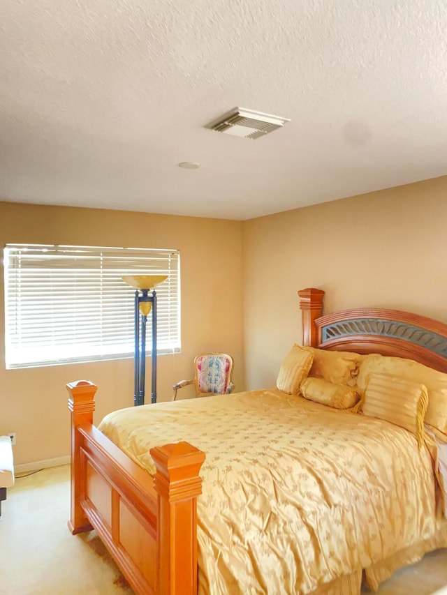 bedroom with a textured ceiling and carpet