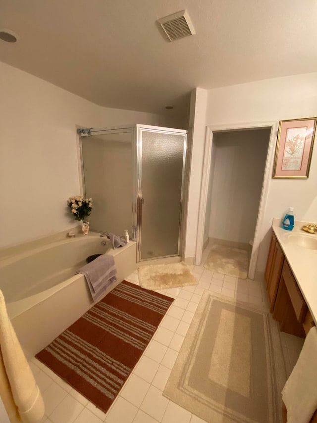 bathroom featuring tile patterned flooring, vanity, and separate shower and tub