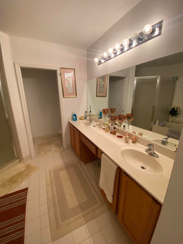 bathroom featuring tile patterned flooring, an enclosed shower, and vanity