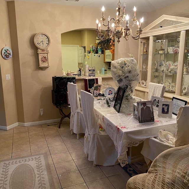 tiled dining room featuring an inviting chandelier