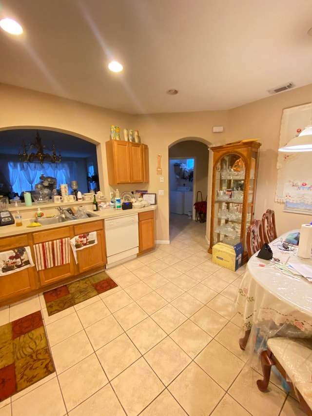 kitchen featuring white dishwasher, sink, and light tile patterned floors