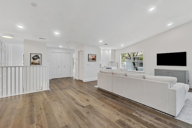 unfurnished living room with wood-type flooring and vaulted ceiling