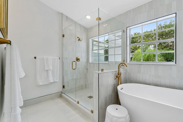 bathroom with a shower with shower door, tile walls, and tile patterned flooring