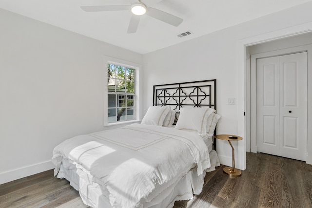 bedroom with dark hardwood / wood-style floors, a closet, and ceiling fan