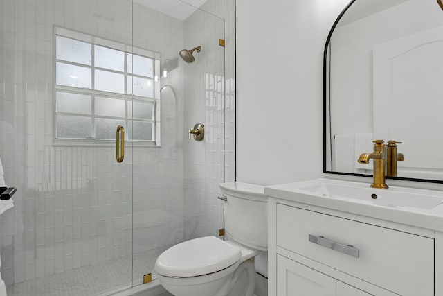 bathroom with an enclosed shower, vanity, and toilet