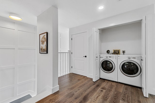 clothes washing area with dark hardwood / wood-style floors and washer and dryer