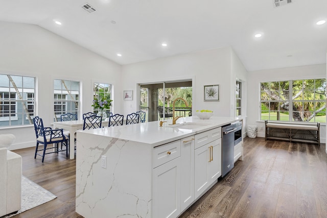 kitchen with dark hardwood / wood-style flooring, an island with sink, vaulted ceiling, white cabinetry, and light stone counters