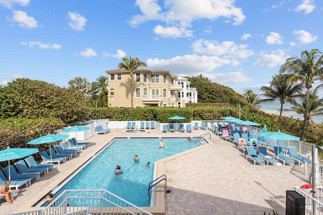 view of swimming pool featuring a patio and a hot tub