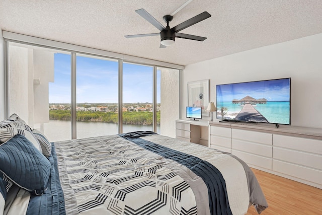 bedroom featuring expansive windows, a textured ceiling, access to outside, and ceiling fan