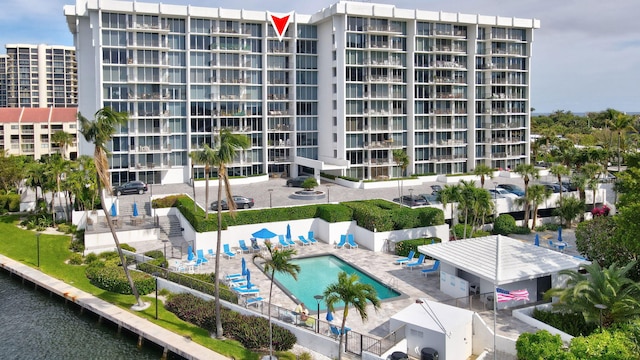 view of building exterior with a water view and a community pool