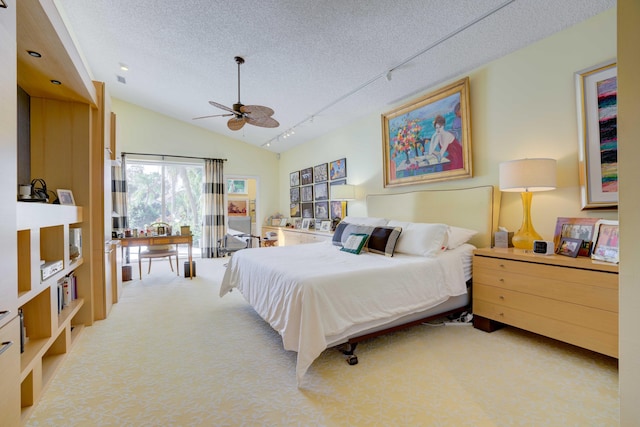 carpeted bedroom with a textured ceiling, lofted ceiling, ceiling fan, and track lighting