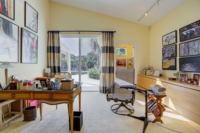 carpeted home office featuring rail lighting and vaulted ceiling