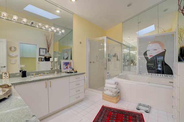 bathroom featuring a skylight, independent shower and bath, tile patterned floors, and vanity