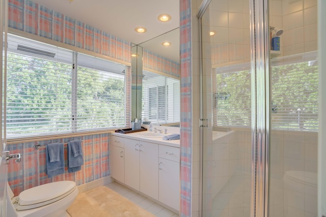 bathroom featuring toilet, vanity, and plenty of natural light