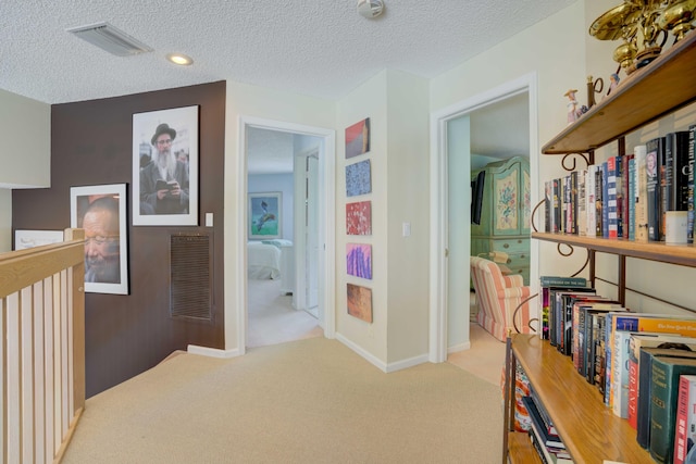 corridor featuring carpet and a textured ceiling