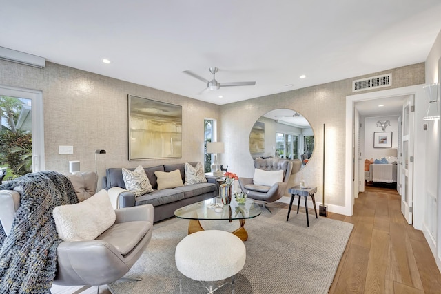 living room featuring ceiling fan and light hardwood / wood-style flooring