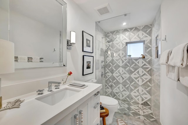 bathroom featuring vanity, walk in shower, and toilet