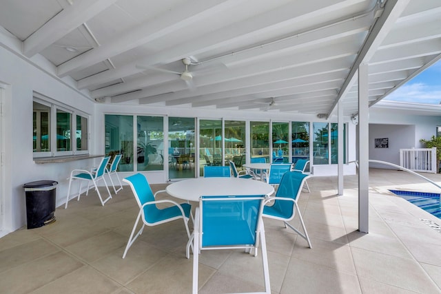 sunroom featuring ceiling fan and beamed ceiling