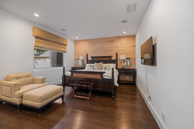 bedroom featuring dark wood-type flooring and wooden walls