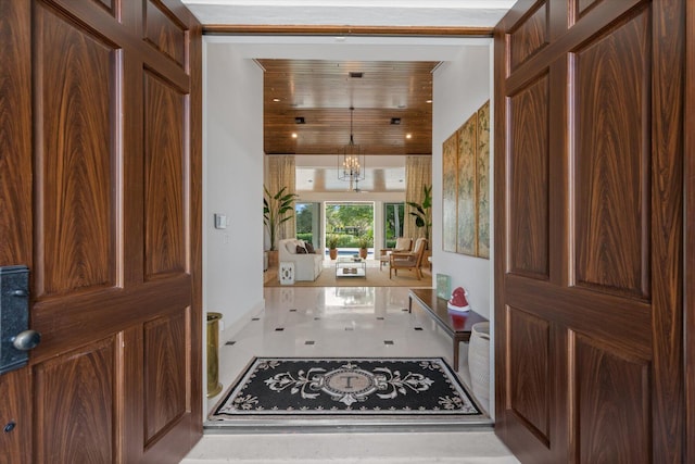 foyer entrance featuring a notable chandelier and wood ceiling