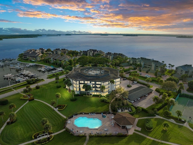 aerial view at dusk featuring a water view