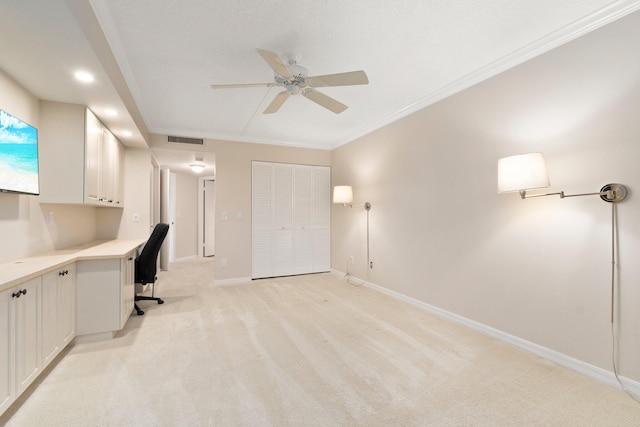 unfurnished office featuring ceiling fan, light colored carpet, and ornamental molding