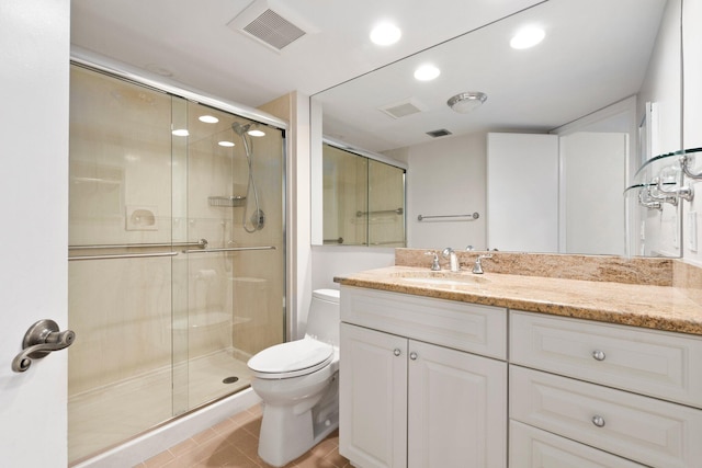 bathroom with tile patterned floors, vanity, walk in shower, and toilet