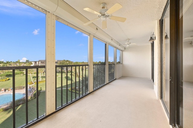 unfurnished sunroom with ceiling fan