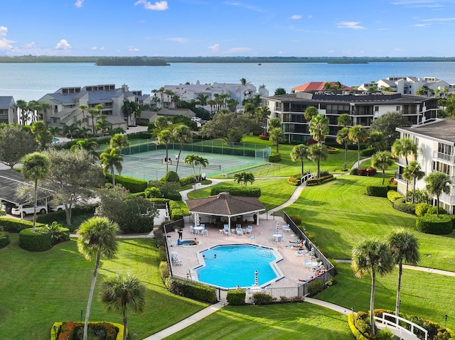 view of swimming pool with a yard, a patio, and a water view