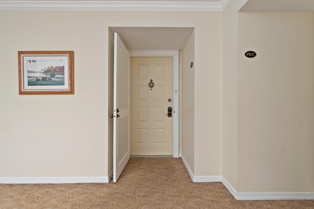 hallway with ornamental molding and light carpet