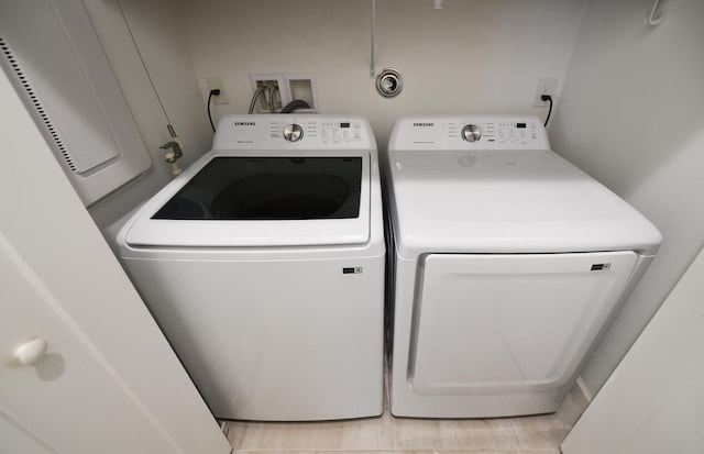 clothes washing area featuring light tile floors, washer hookup, and independent washer and dryer