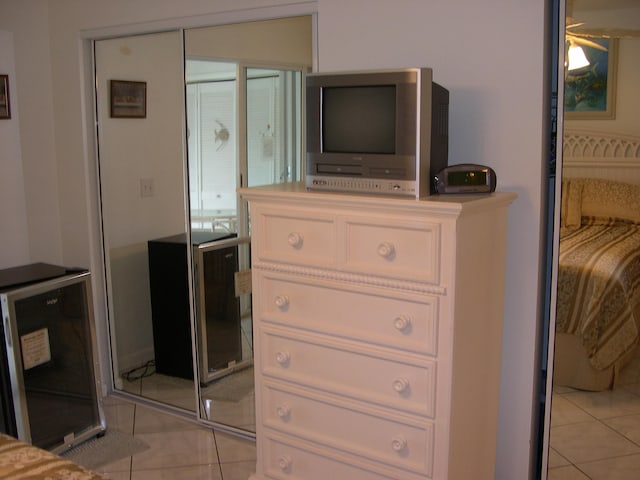 bedroom with a closet, wine cooler, and light tile patterned floors