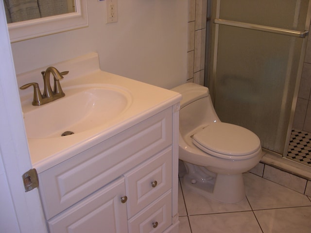 bathroom featuring vanity, toilet, an enclosed shower, and tile patterned floors