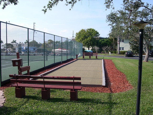 surrounding community with a yard and tennis court