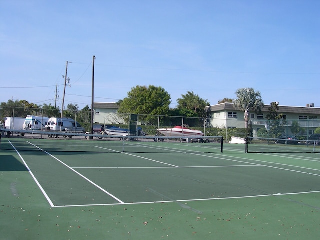 view of tennis court with basketball hoop