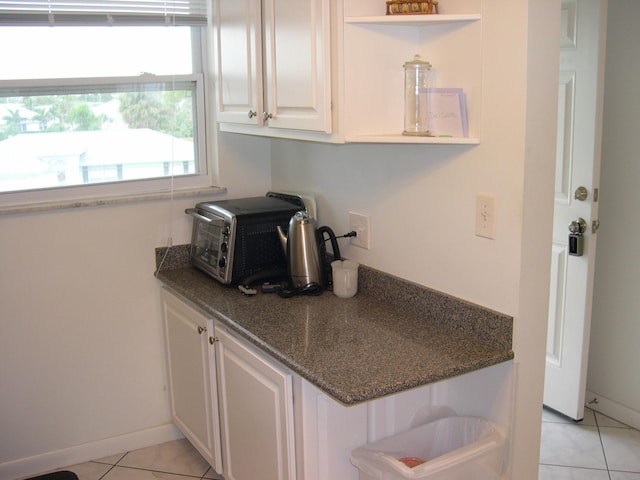 kitchen with light tile patterned floors and white cabinets