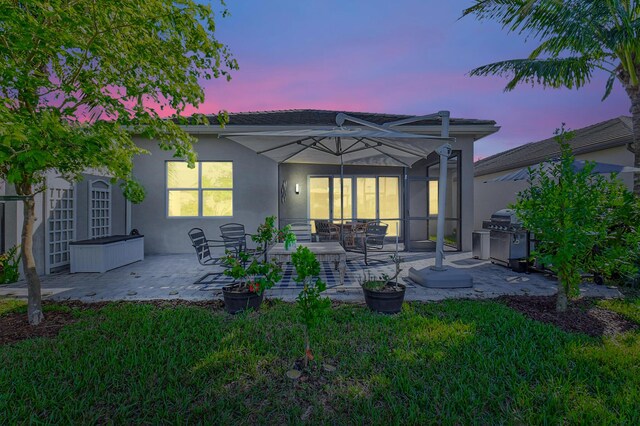 back house at dusk with a patio area