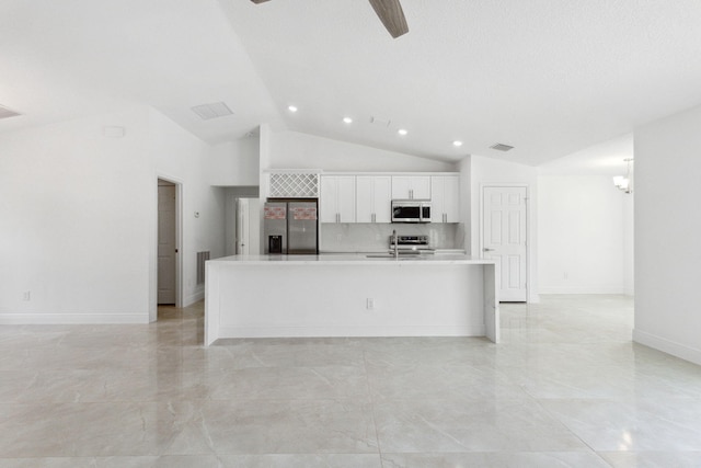 kitchen with stainless steel appliances, vaulted ceiling, sink, a center island with sink, and white cabinetry