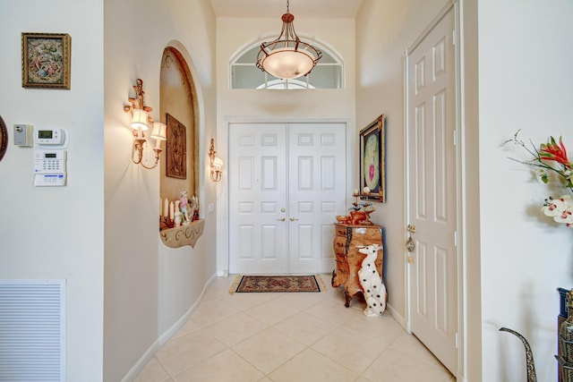 foyer featuring light tile patterned flooring, visible vents, and baseboards